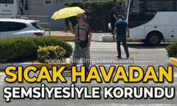 Sıcak havadan şemsiyesiyle korundu