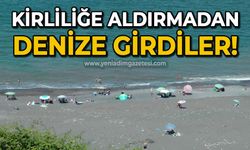 Kirliliğe aldırmadan denize girdiler!