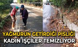 Yağmurun getirdiği pisliği kadın işçiler temizliyor