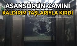 Asansörün camını kaldırım taşlarıyla parçaladı