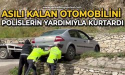 Asılı kalan otomobilini polislerin yardımıyla kurtardı