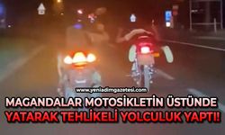 Magandalar motosikletin üstünde yatarak tehlikeli yolculuk yaptı!