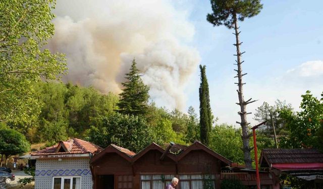 Elinde hortumla otları ıslatarak evini yangından korumaya çalıştı