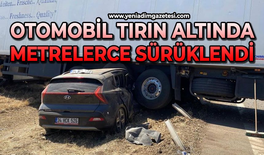 Otomobil, tırın altında metrelerce sürüklendi