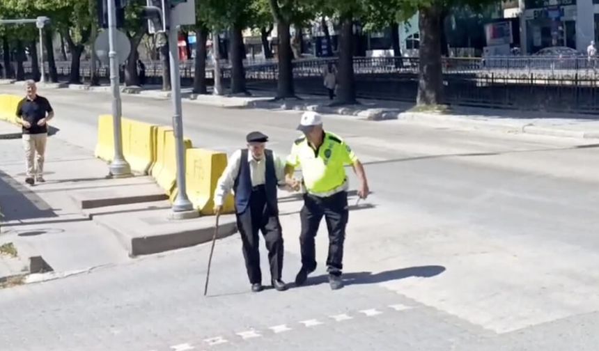 Trafik polisinin yürümekte zorlanan yaşlı adama yardımı yürekleri ısıttı